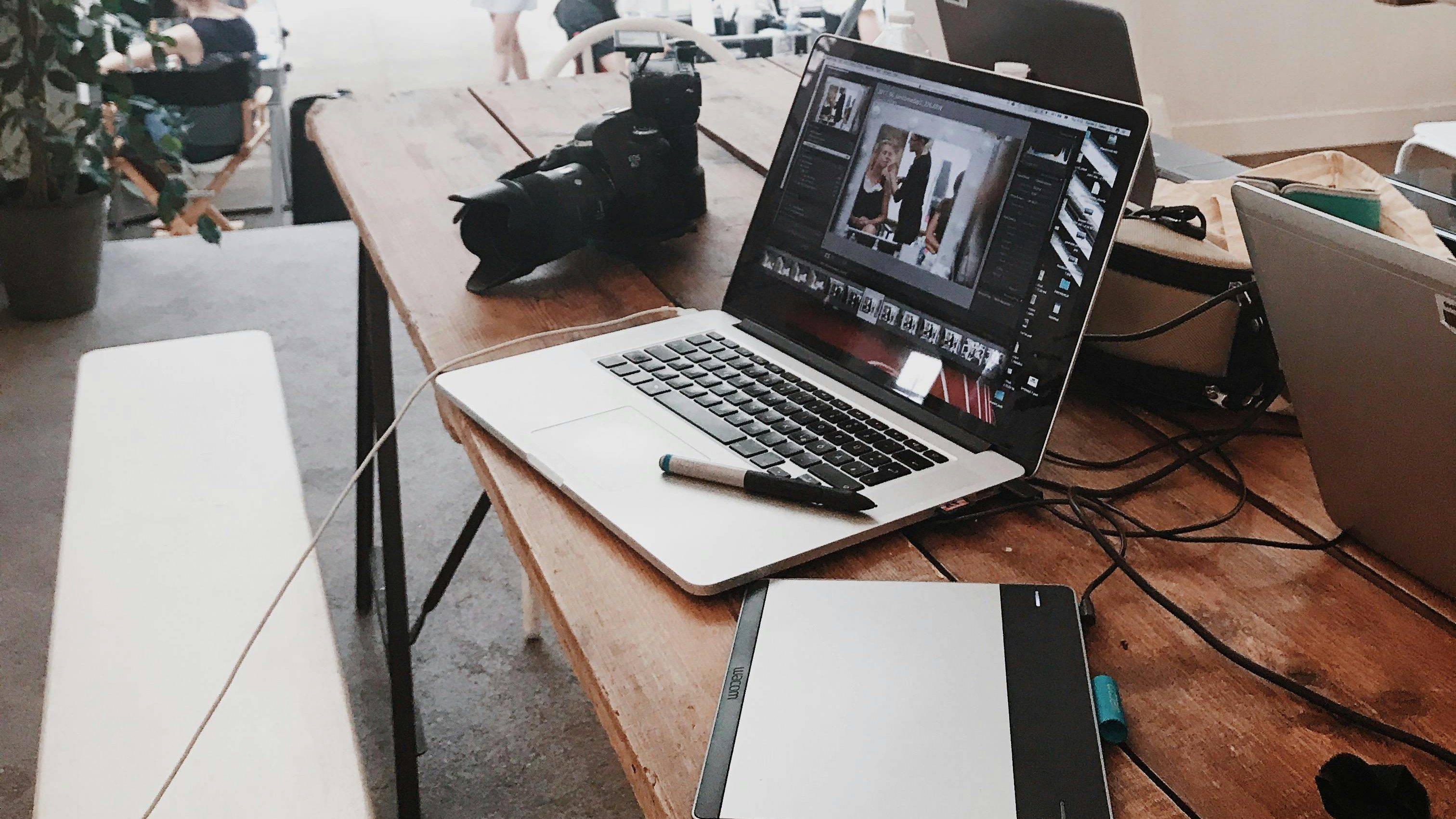 Schreibtisch mit Laptop, Kamera und Notizbuch, vorbereitet für journalistische Arbeit